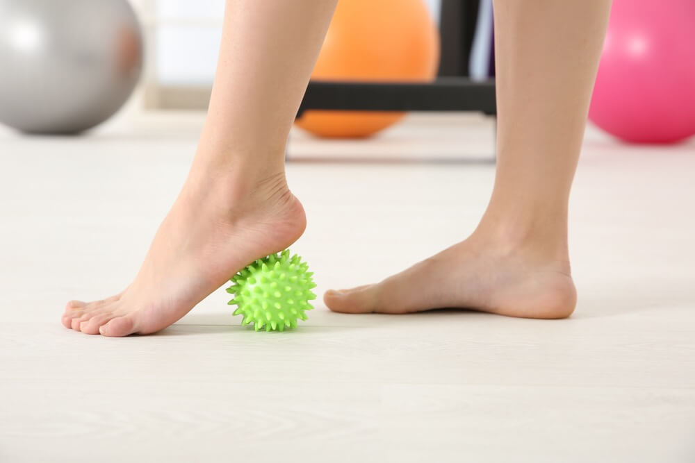 A pair of flat feet exercising with a ball